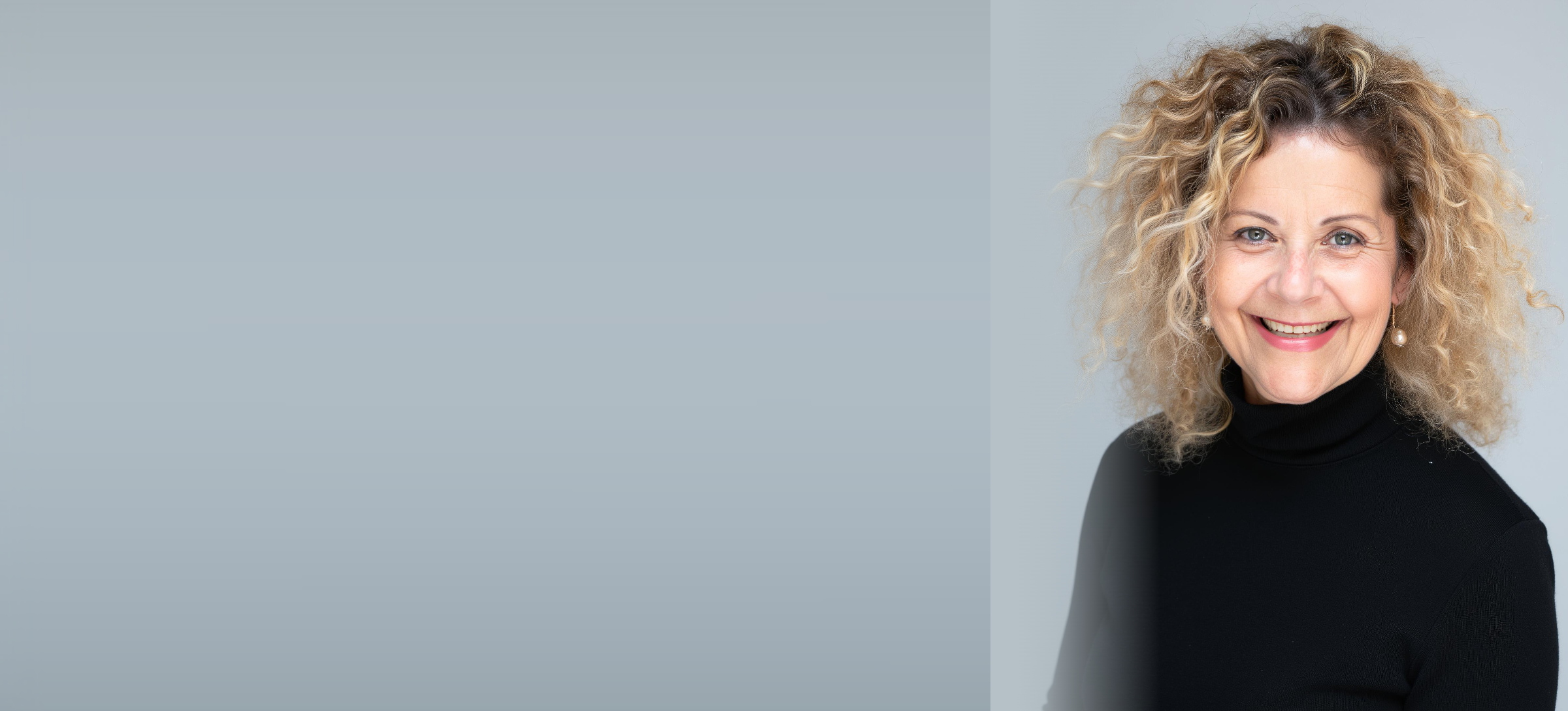 Margalit Grunberger smiling, photographed against a soft gray studio ground.