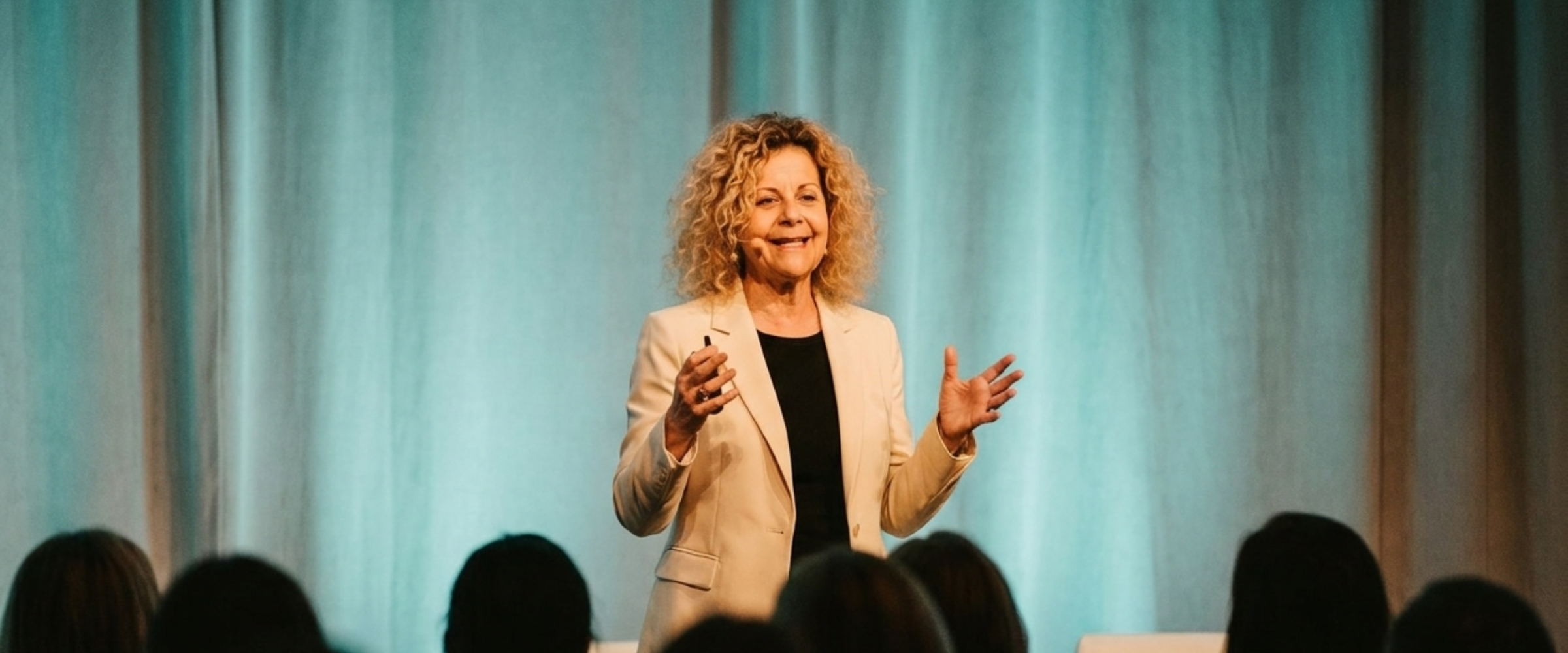 Margalit speaking on stage to a seated audience